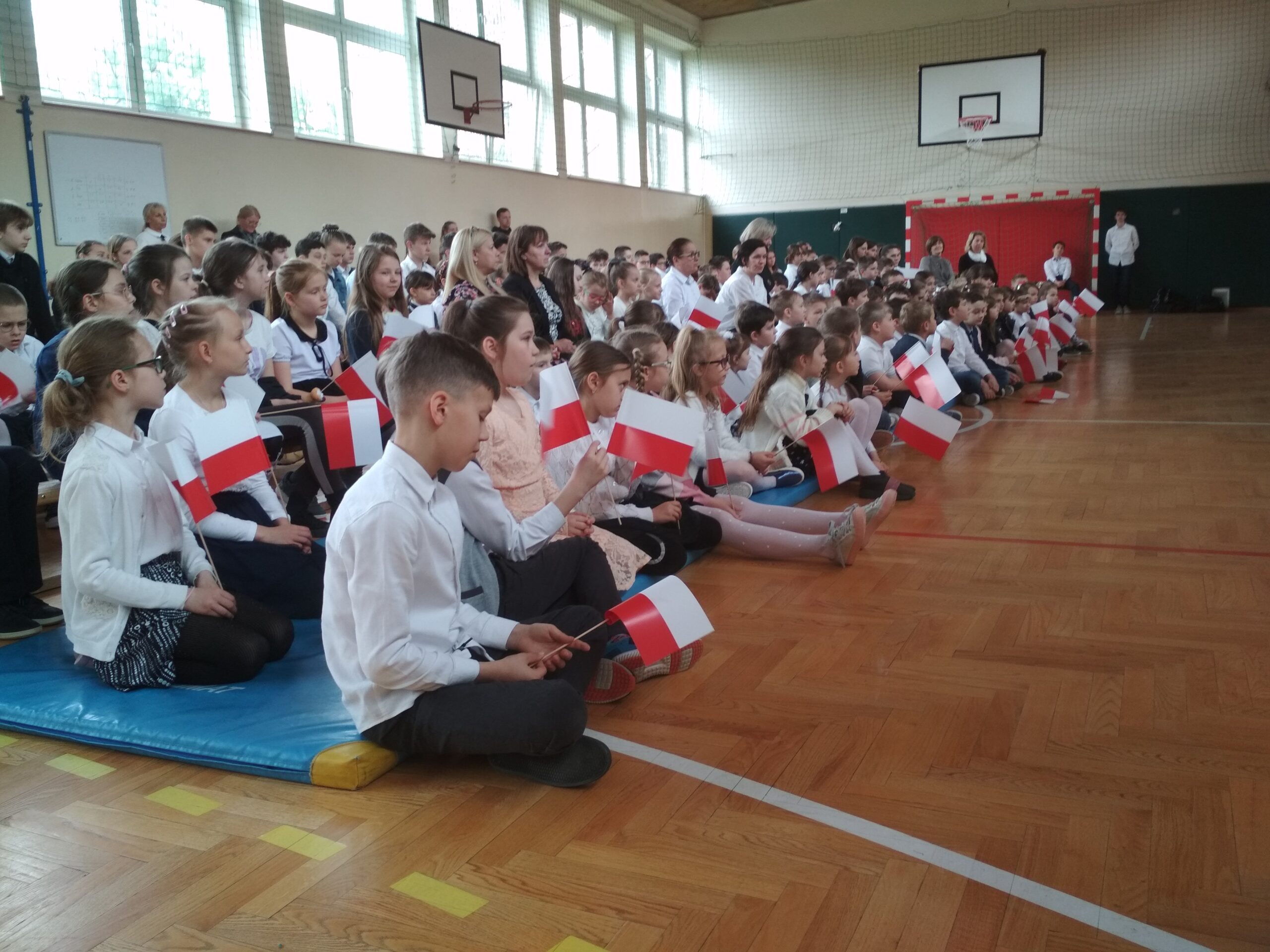 Uczniowie z białoczerwoną flagą