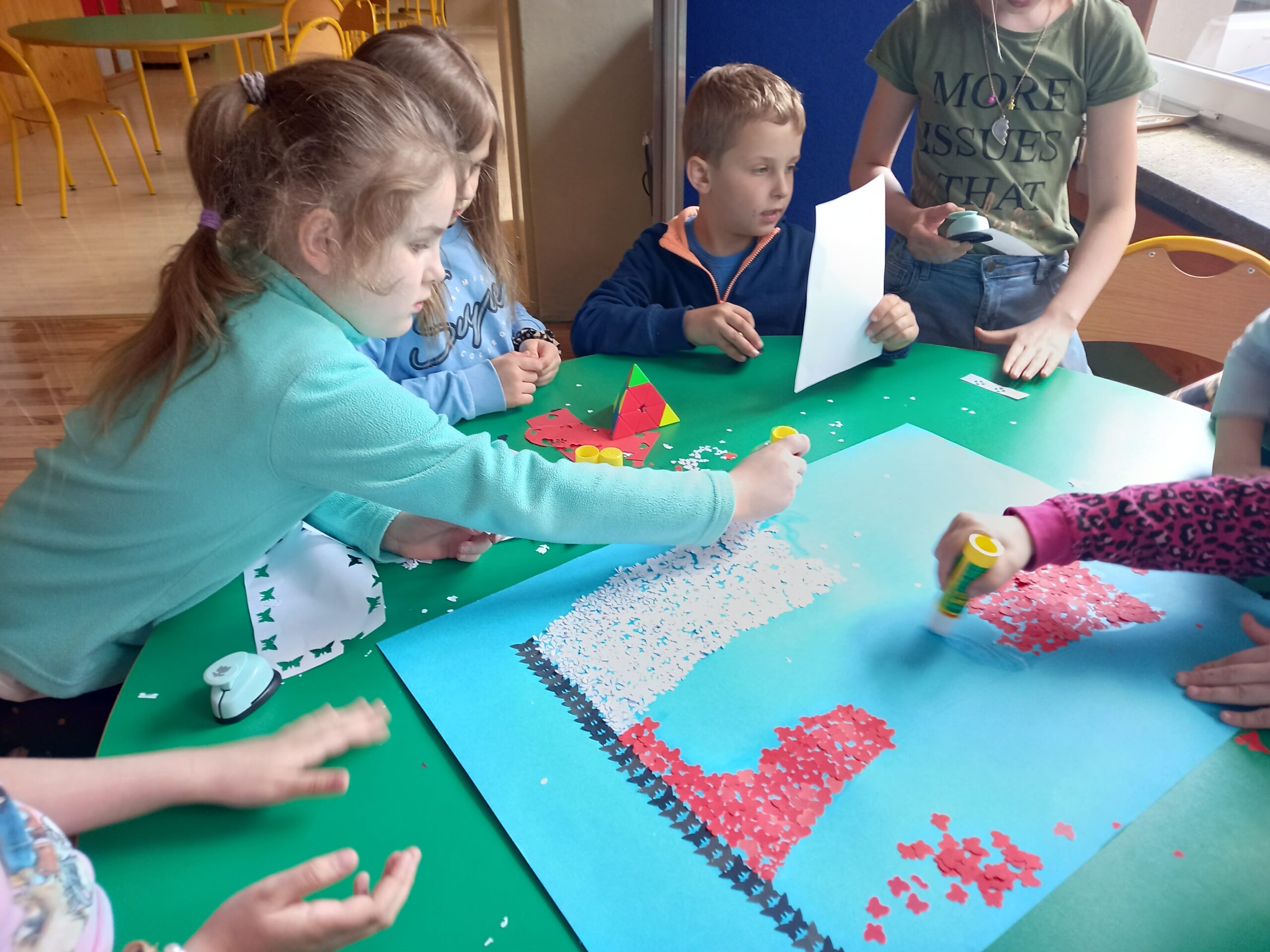 Dzieci podczas tworzenia pracy plastycznej  - flaga Polski